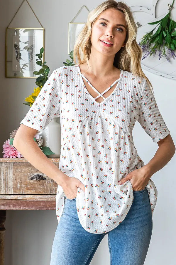 White ditsy floral babydoll blouse with V-neck crisscross straps and short sleeves