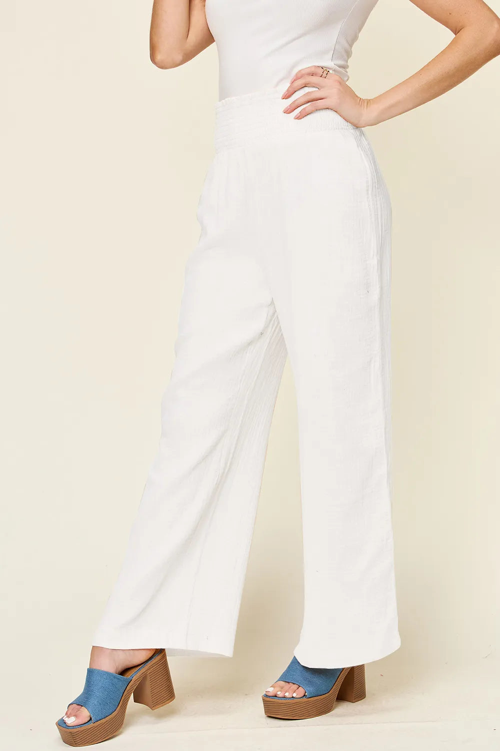 White wide-leg pants with smocked waist and airy drape, front view