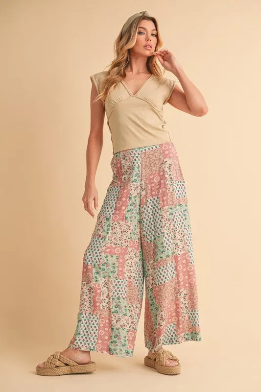 Wide-leg patchwork pants in mint/pink floral print, front view with draped fabric