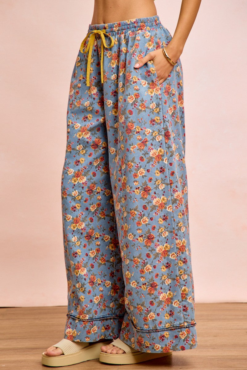 Floral denim wide pants, front view of drawstring tie and elastic waist; wide relaxed legs