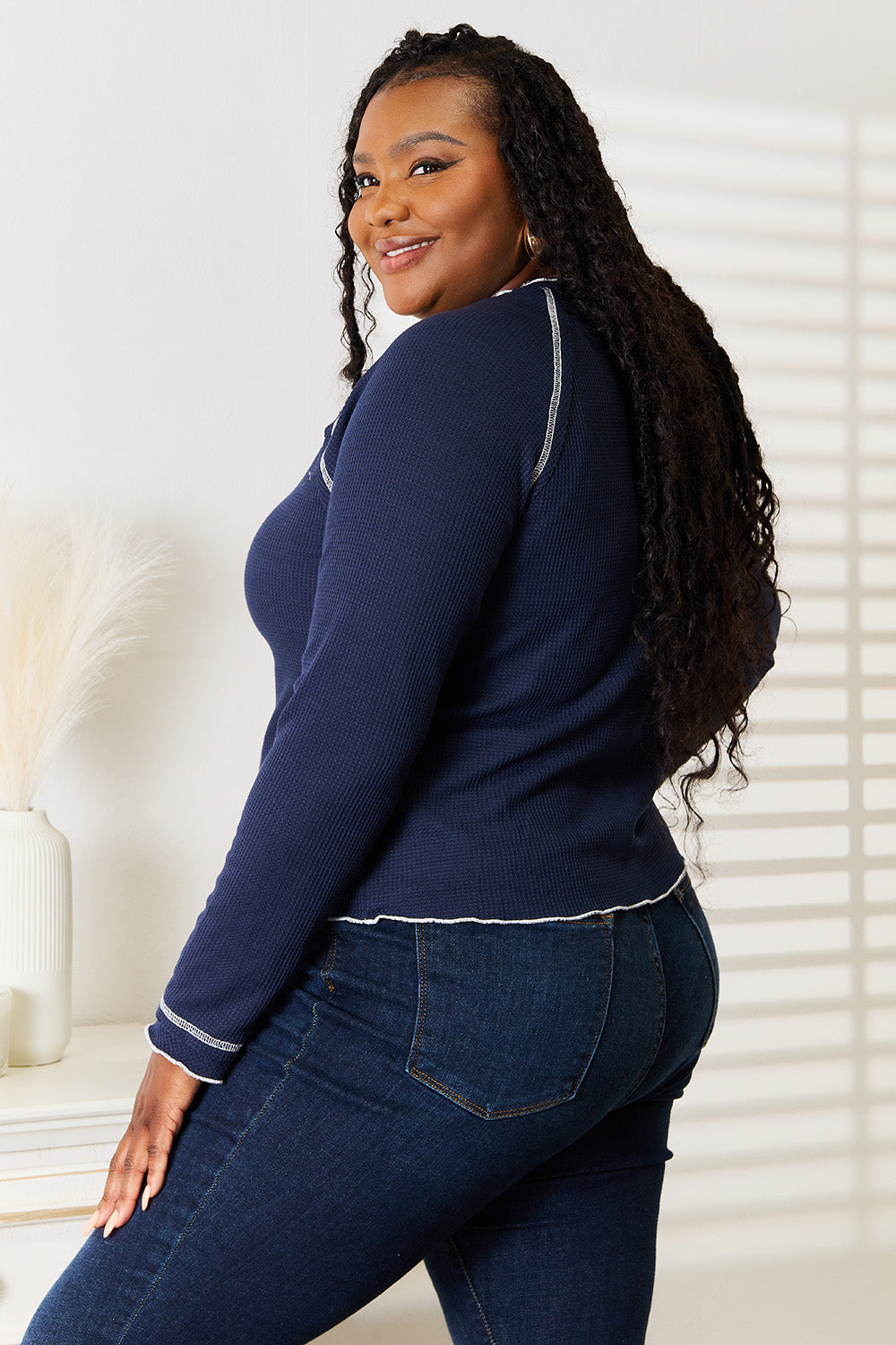 Side view of dark blue long raglan sleeve top with white contrast trim on sleeve