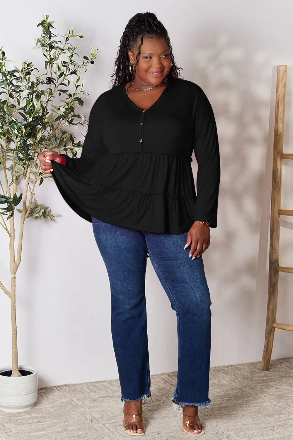 Black long-sleeve blouse with half-button placket and tiered ruffle hem