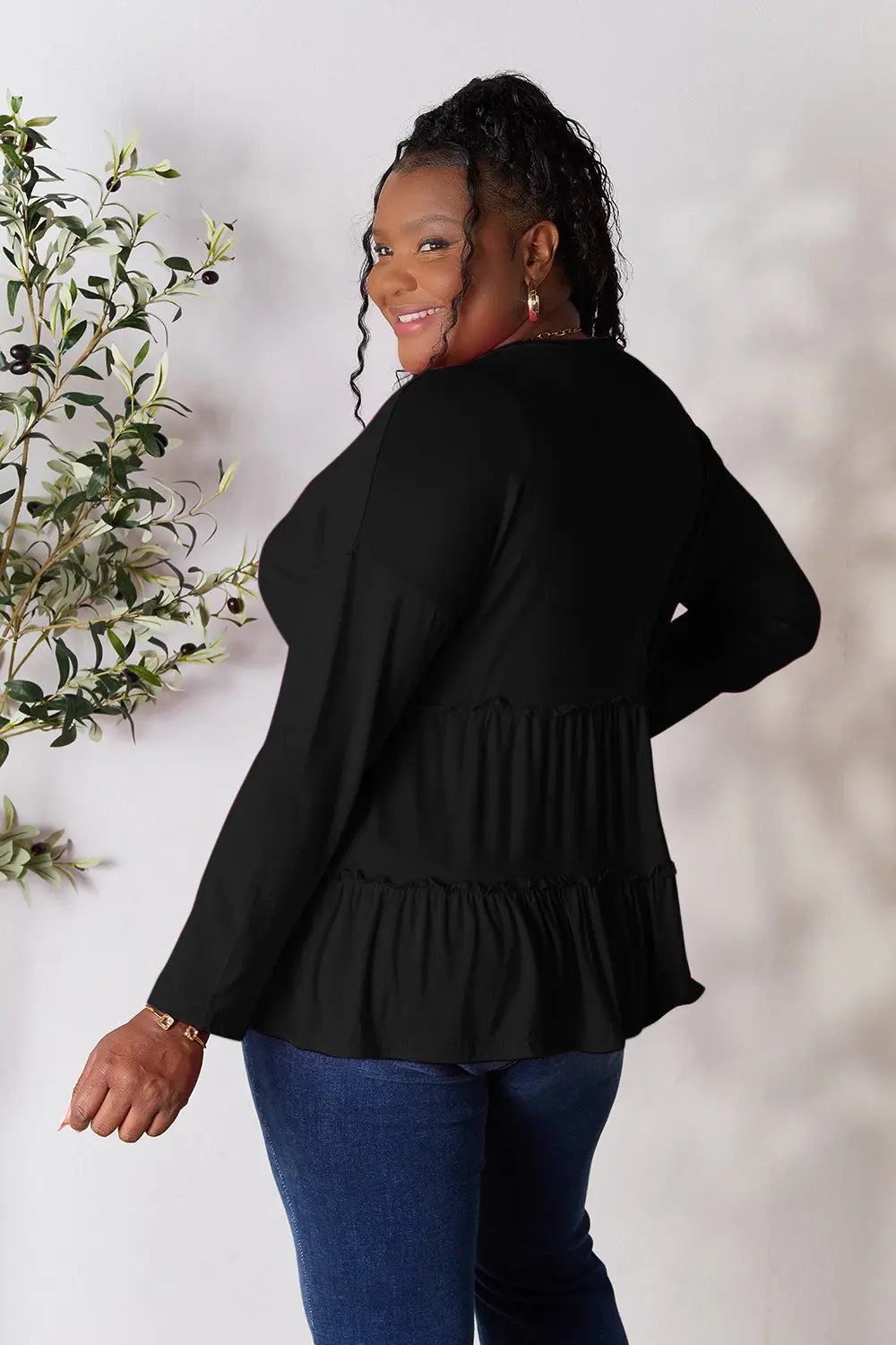Black long sleeve blouse with tiered ruffle hem (back view)
