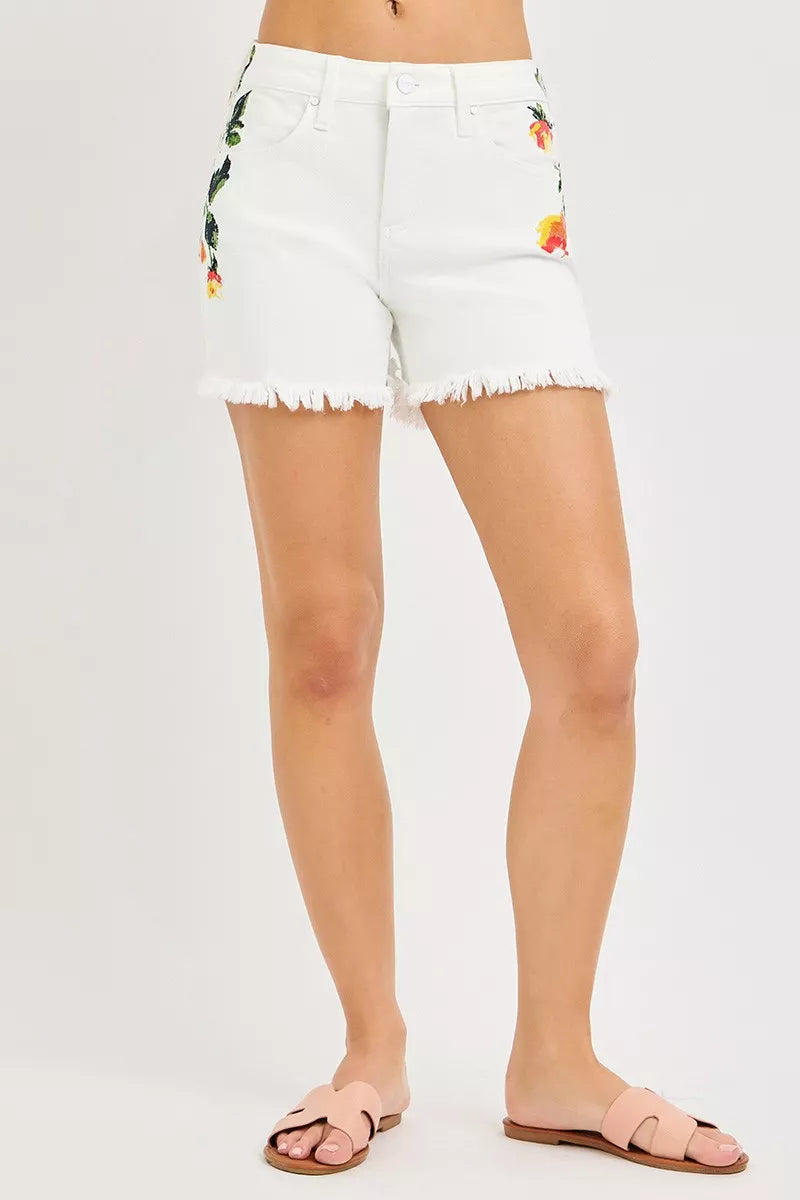 Front view white floral high-rise denim shorts with frayed hem and button fly