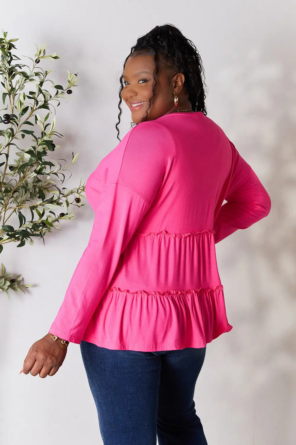 Hot pink tiered ruffle blouse from back with long sleeves and V-neck detail