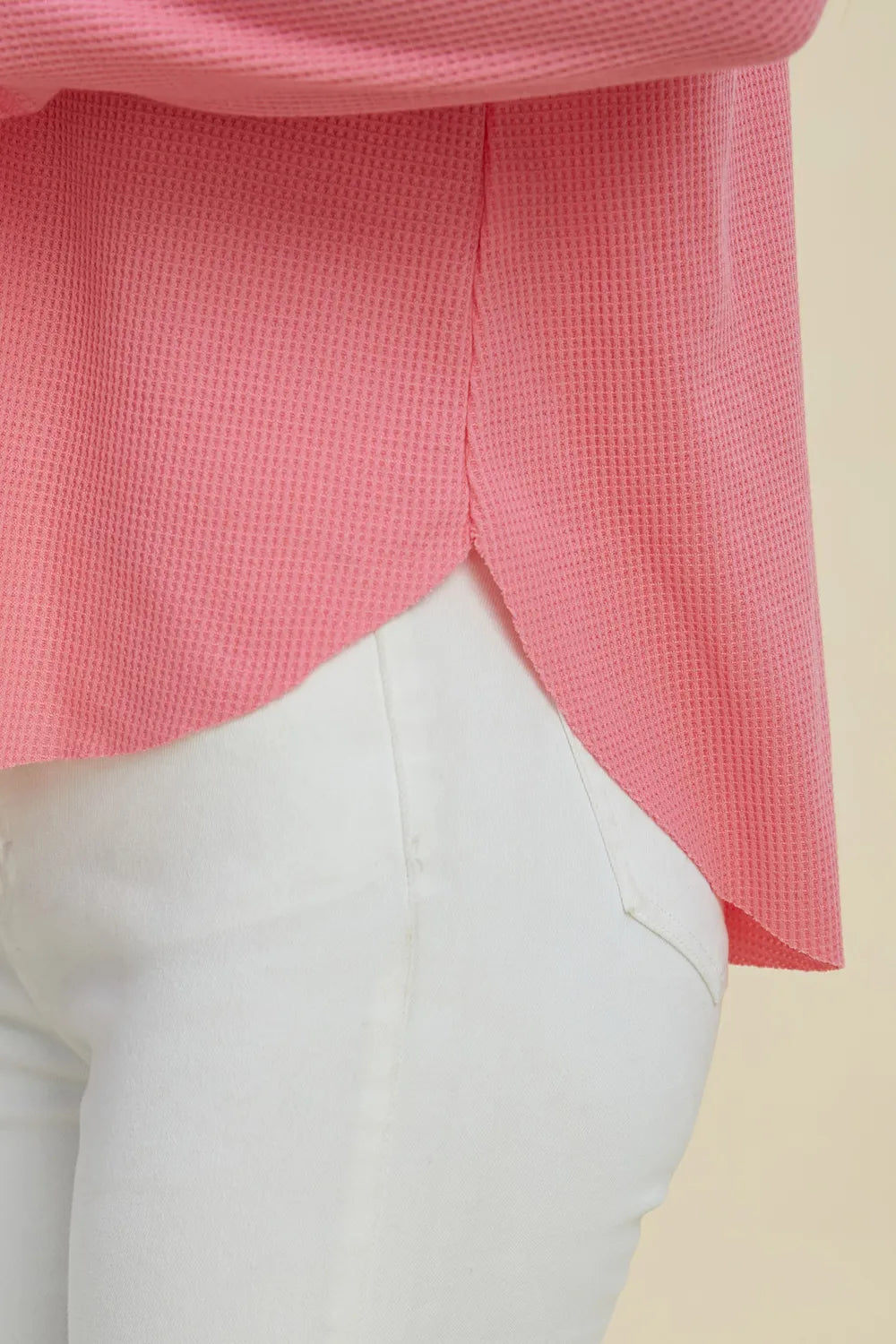 Pink hoodie hem and kangaroo pocket area, high-low layered look