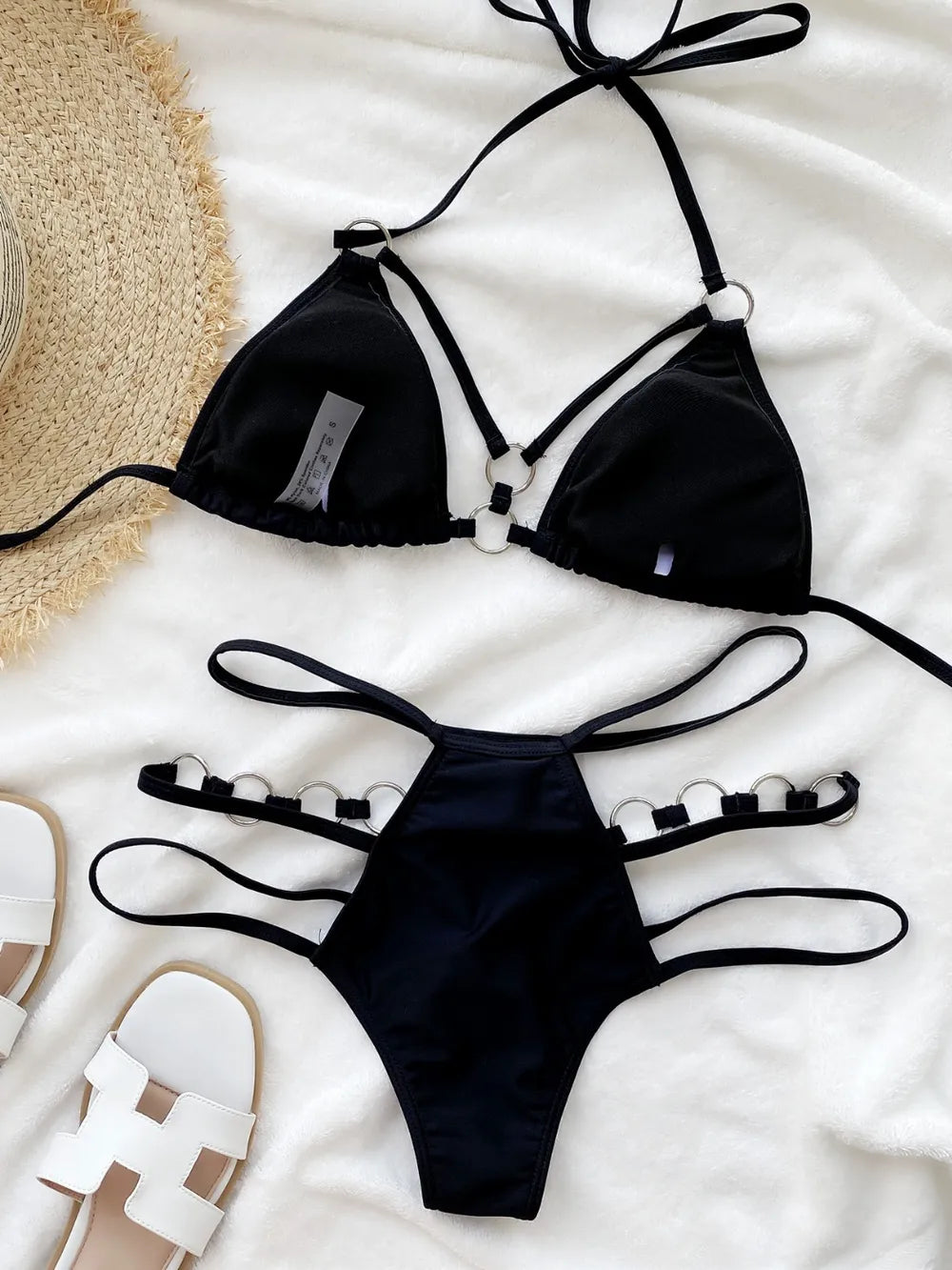 Black triangle halter bikini top and thong-style bottom with ring detail