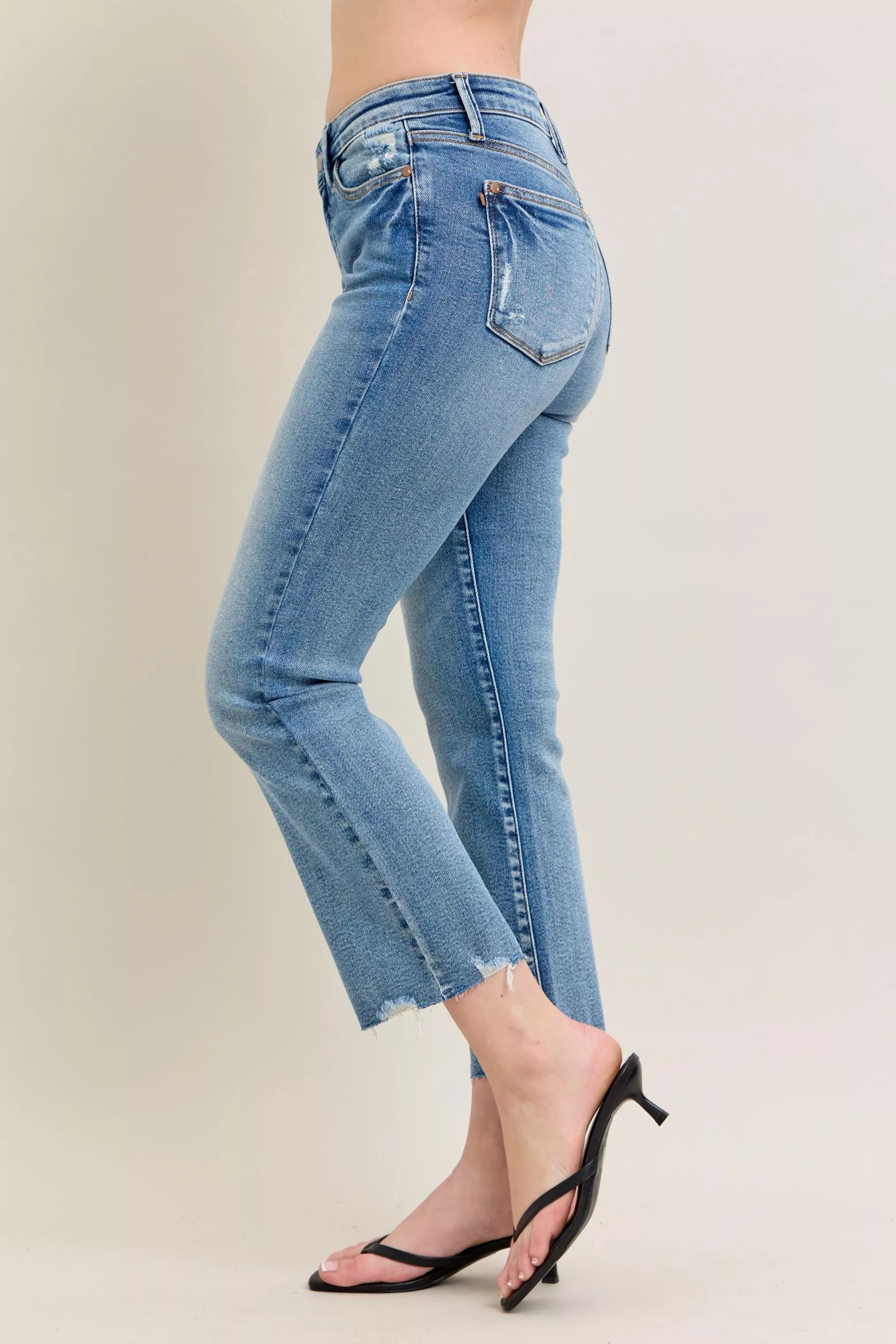 Medium-wash kick flare jeans, side view with destroyed frayed hem