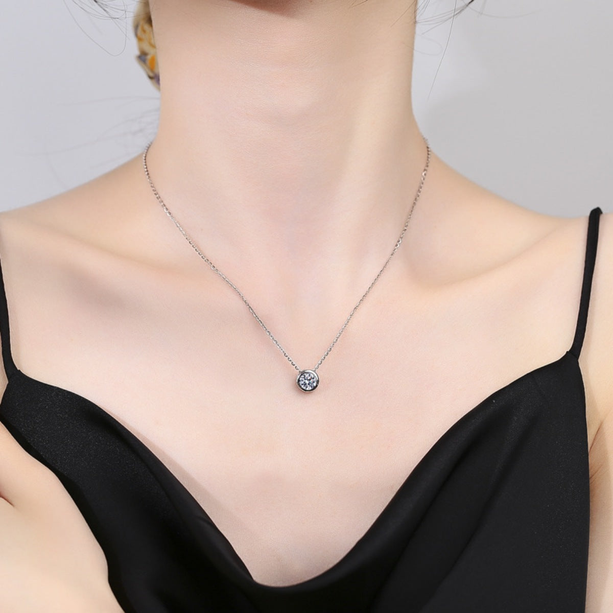 Sterling silver moissanite pendant necklace worn on neck with round solitaire pendant