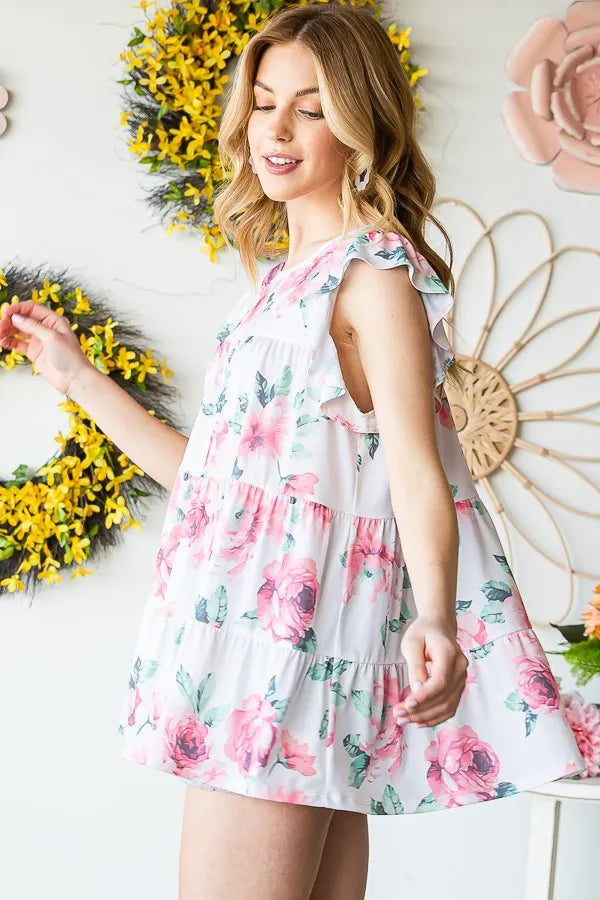 Cream floral tiered babydoll top with flutter sleeves and round neck, angled view