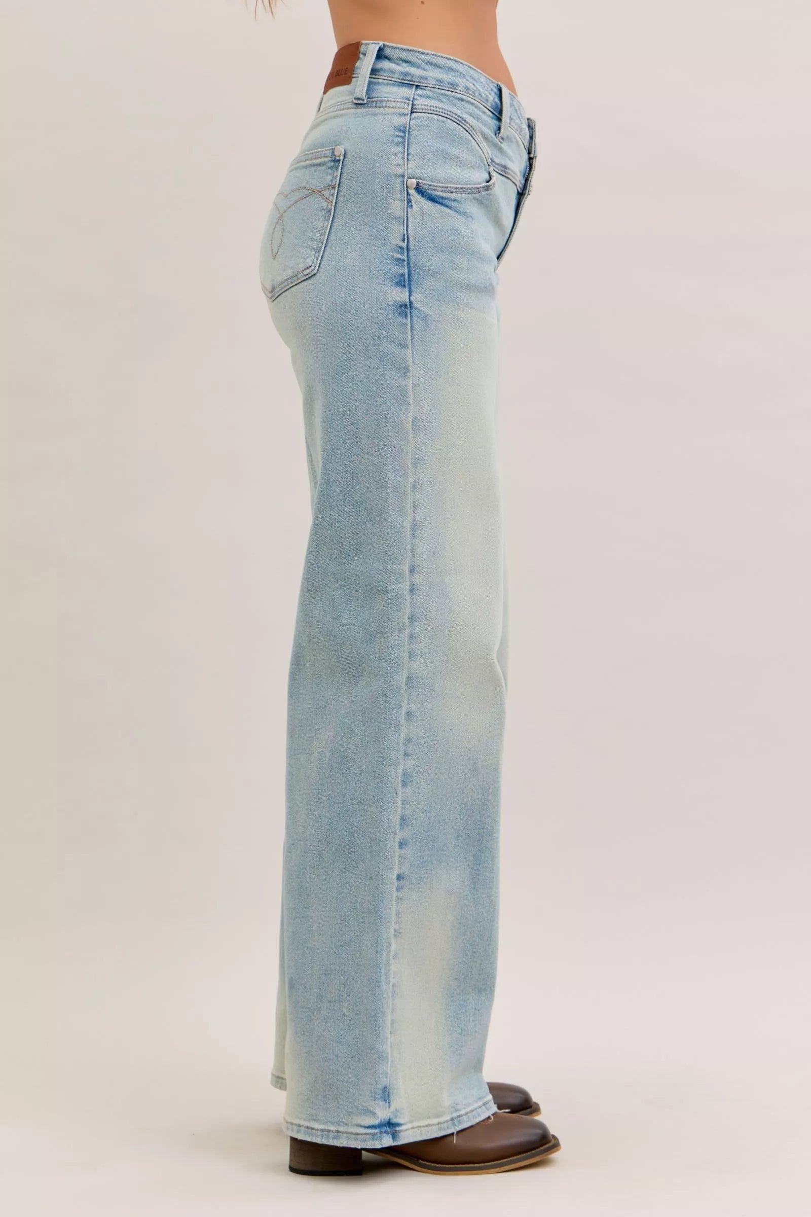 Light blue high-waist straight jeans, side view with back pocket stitching and belt loops