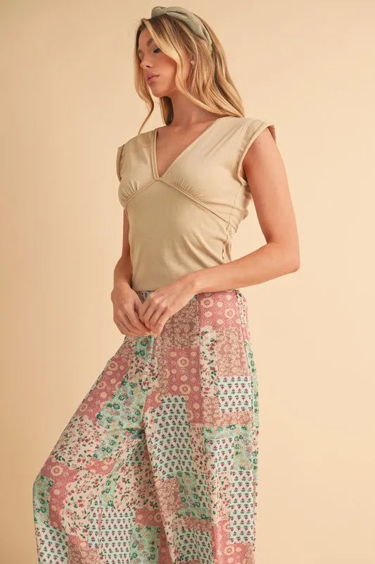 Printed wide-leg pants in mint/pink patchwork floral blocks, side profile view
