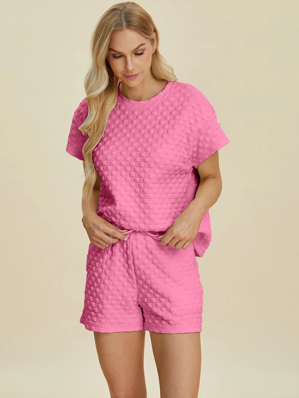 Pink textured lounge set: crew neck T-shirt and matching shorts, laid-back side view