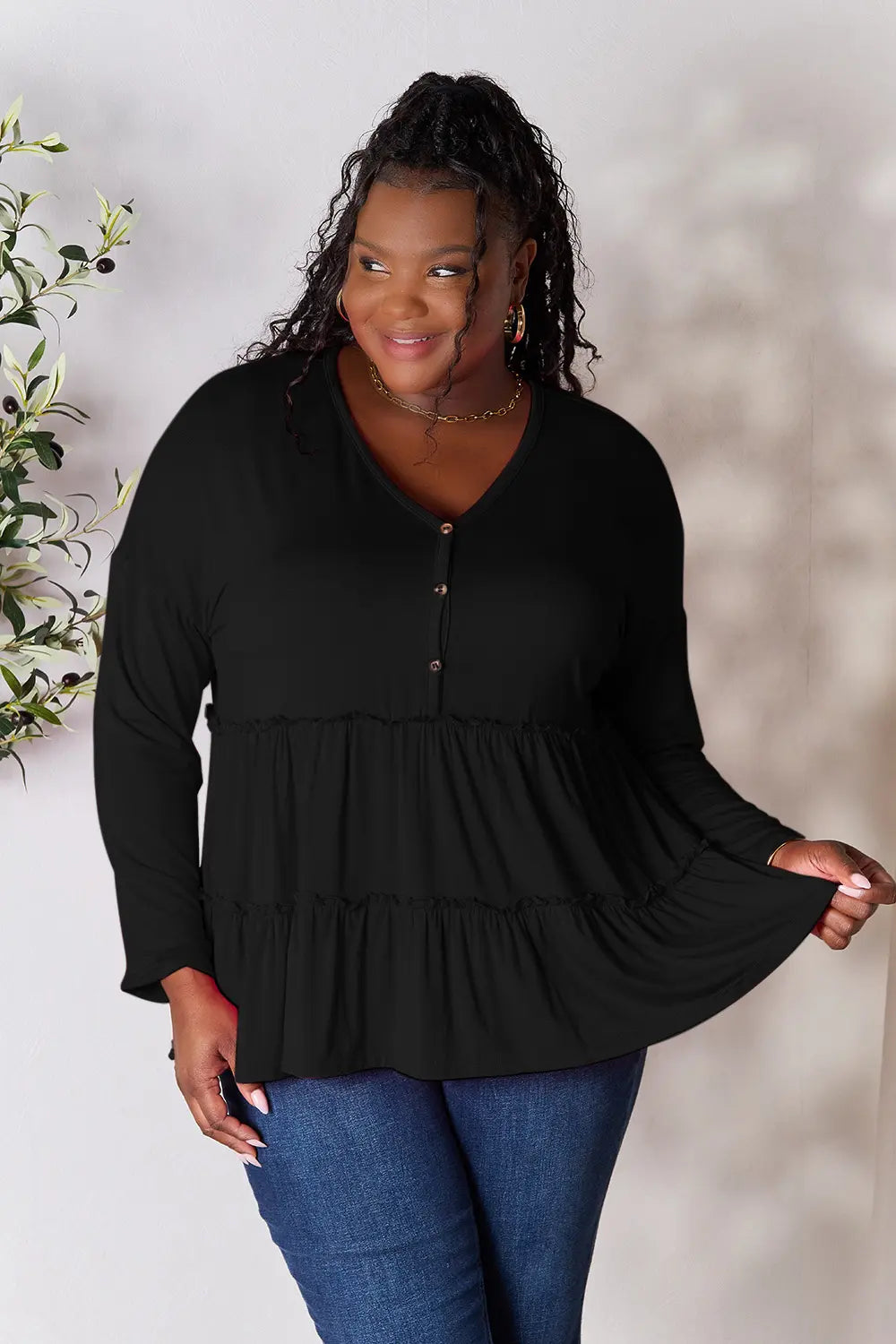Black long sleeve blouse with half-button front and ruffle tier hem