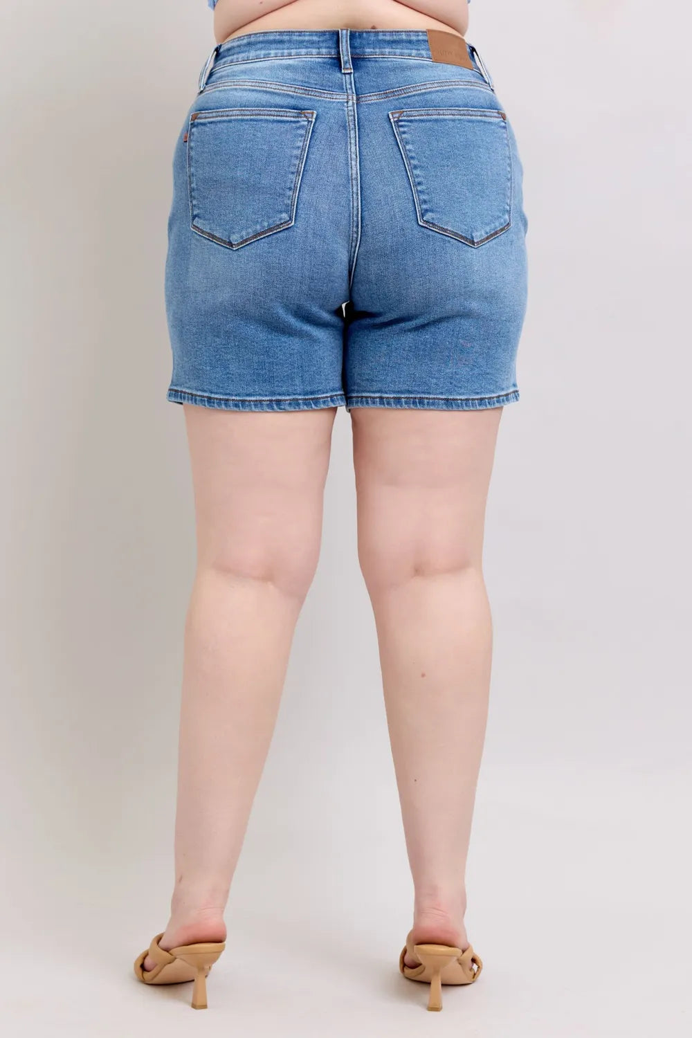 Back view: medium wash plus-size denim shorts with two rear pockets