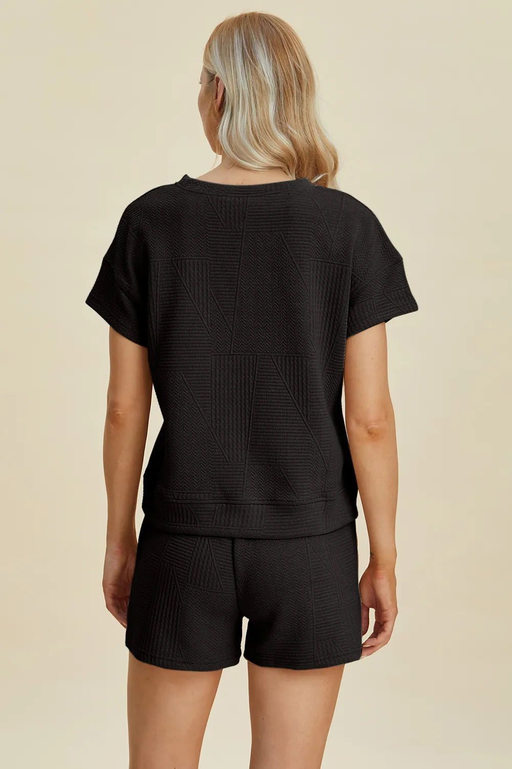 Back view: black textured short-sleeve top and drawstring shorts set.