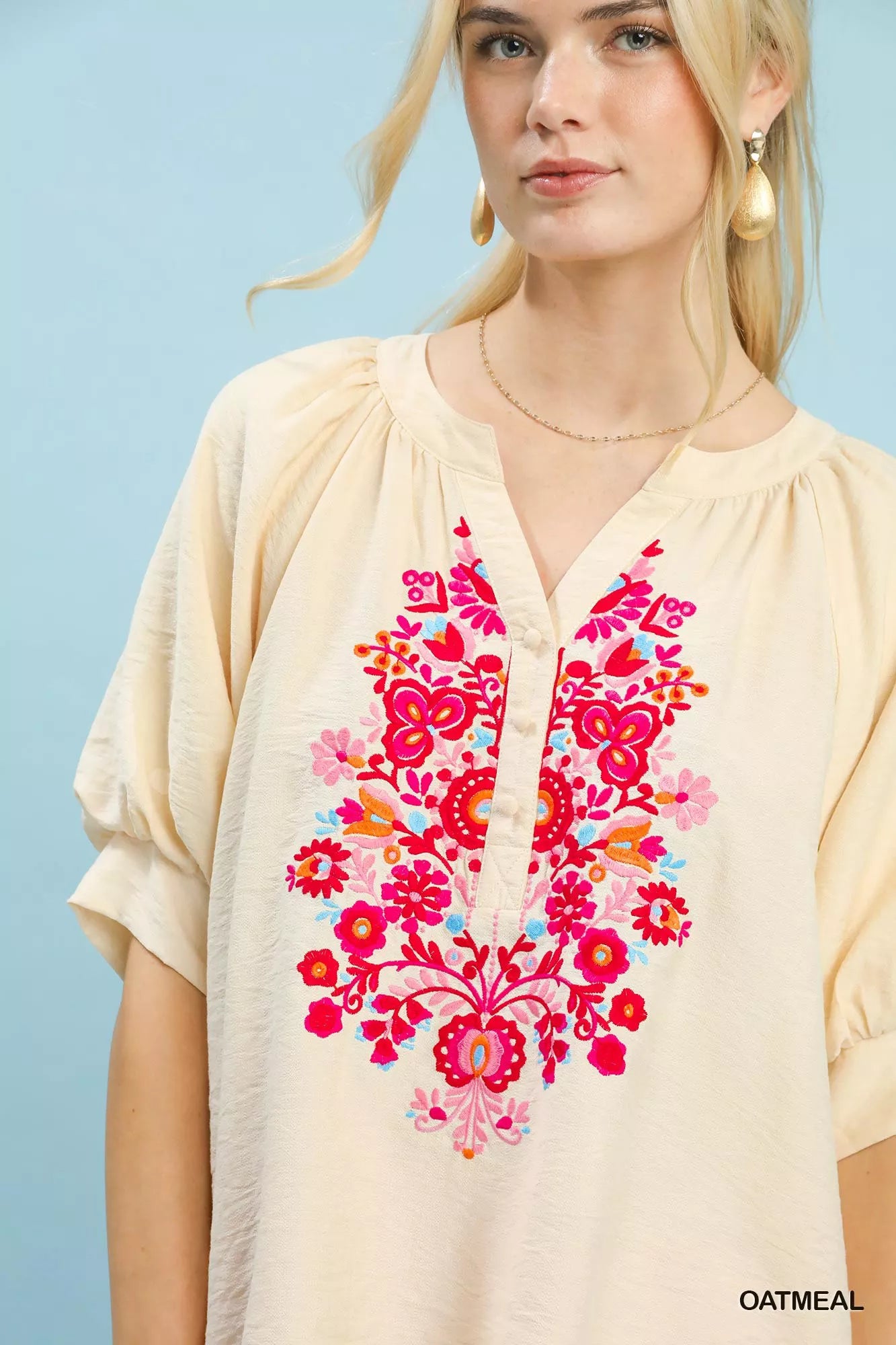 OATMEAL blouse close-up with bright pink floral embroidery down the center