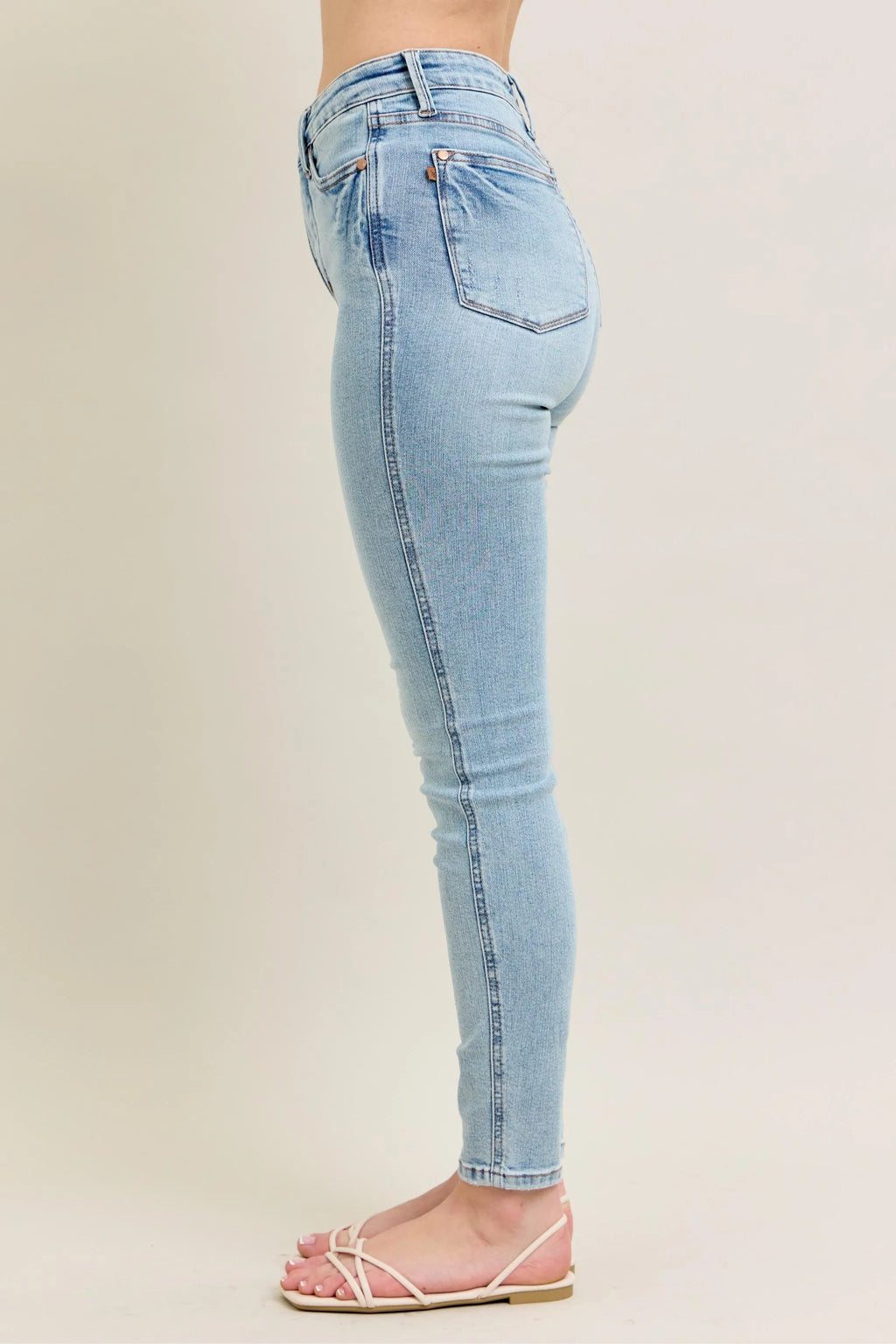 Light wash skinny jeans, side back view, contoured seams and straight ankle cuff