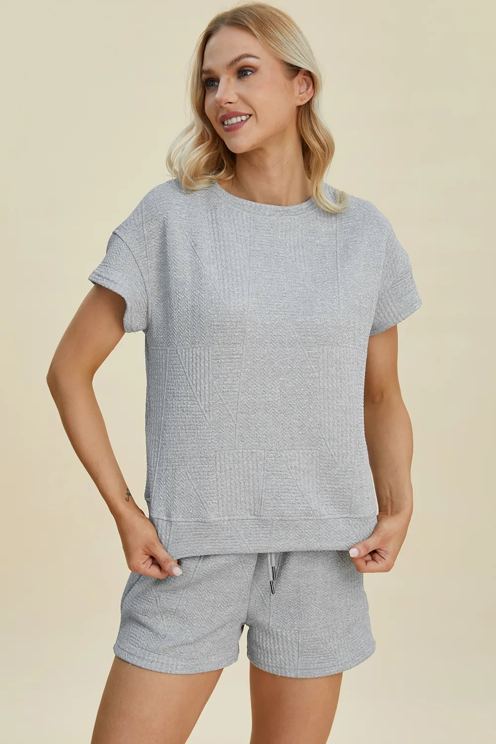 Gray texture set with short sleeves and drawstring shorts, front view holding waistband