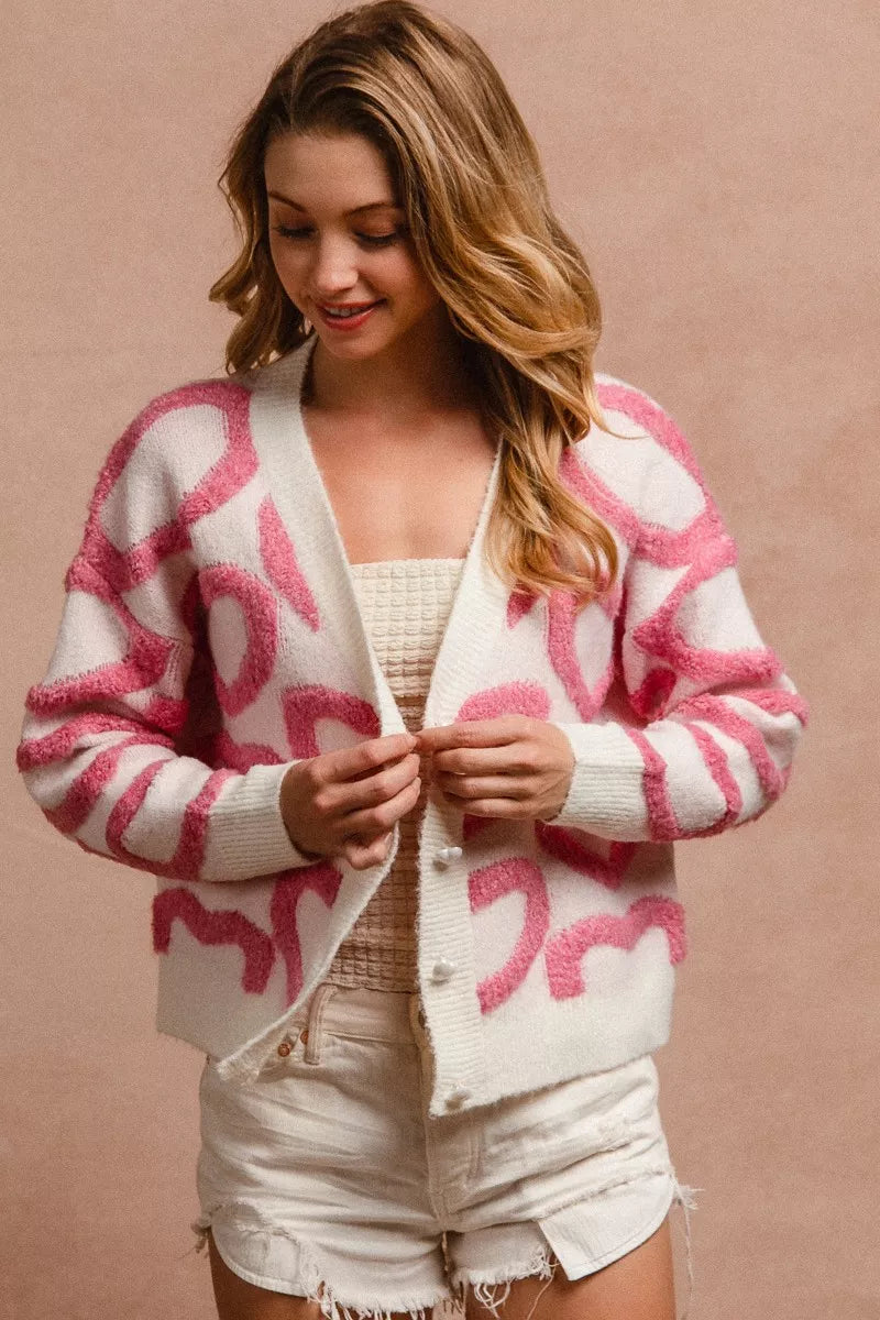 Cardigan V blanco con botones, estampado rosa de corazones y dobladillo abotonado
