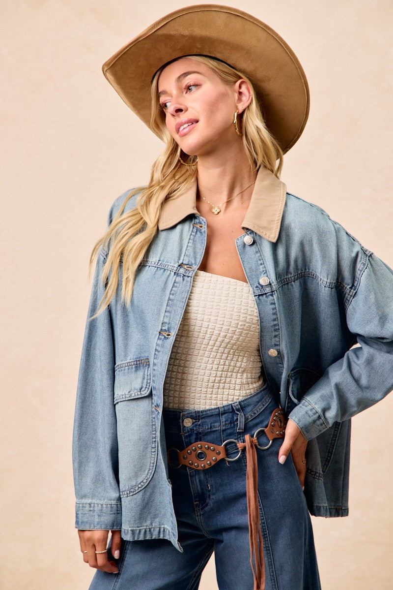 Denim jacket with contrast collar, button front, and relaxed fit over denim jeans.