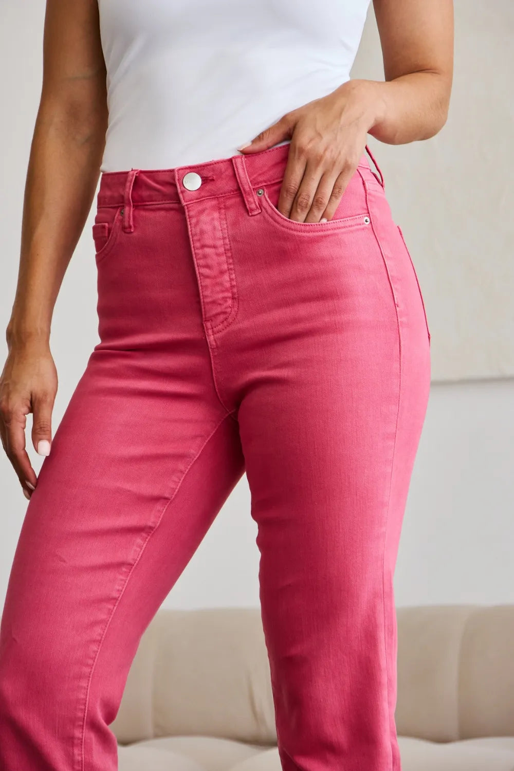 Sunkissed pink jeans showing waistband, button, and front pocket stitching