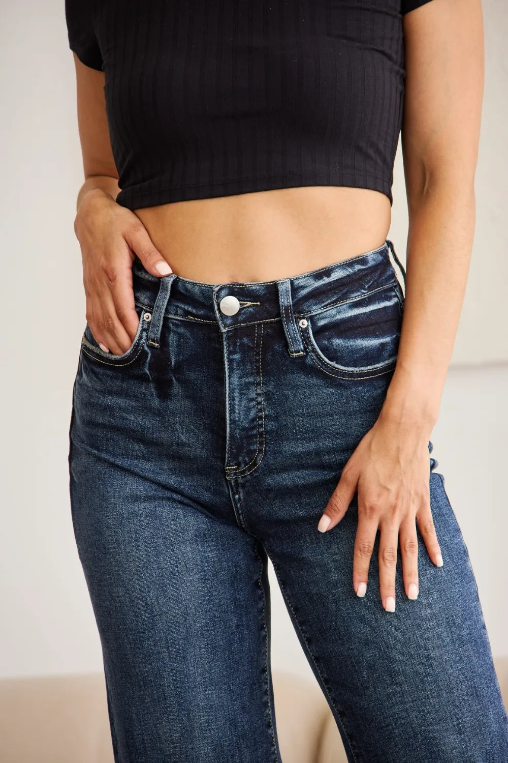 High-waist tummy-control jeans with button closure and pocket seams, dark wash