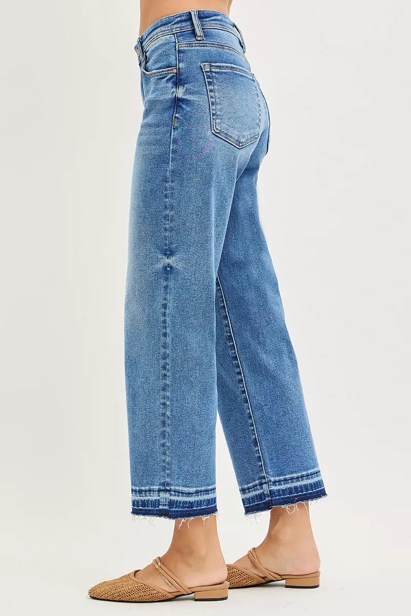 Side view of medium-wash cropped boyfriend jeans with relaxed fit and button pockets