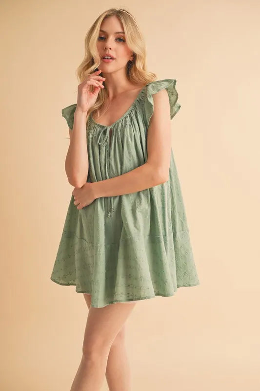 Front view: Pistachio mini tunic dress with ruffled cap sleeves and front drawstring detail