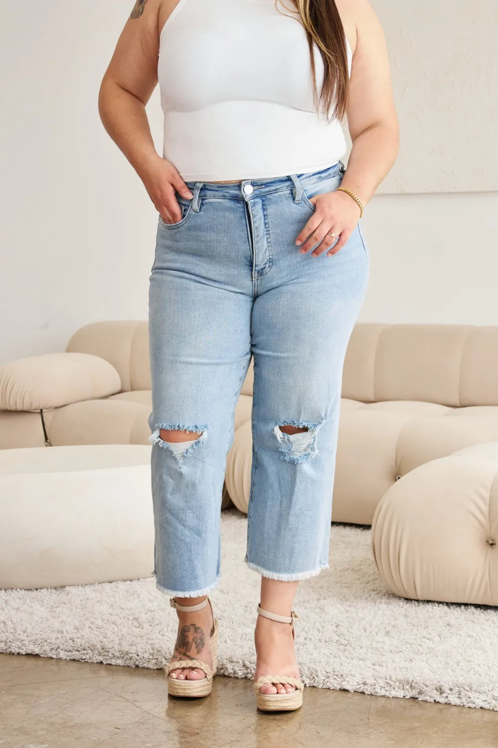 Light wash high-waist tummy control jeans with raw frayed hem and ripped front knees