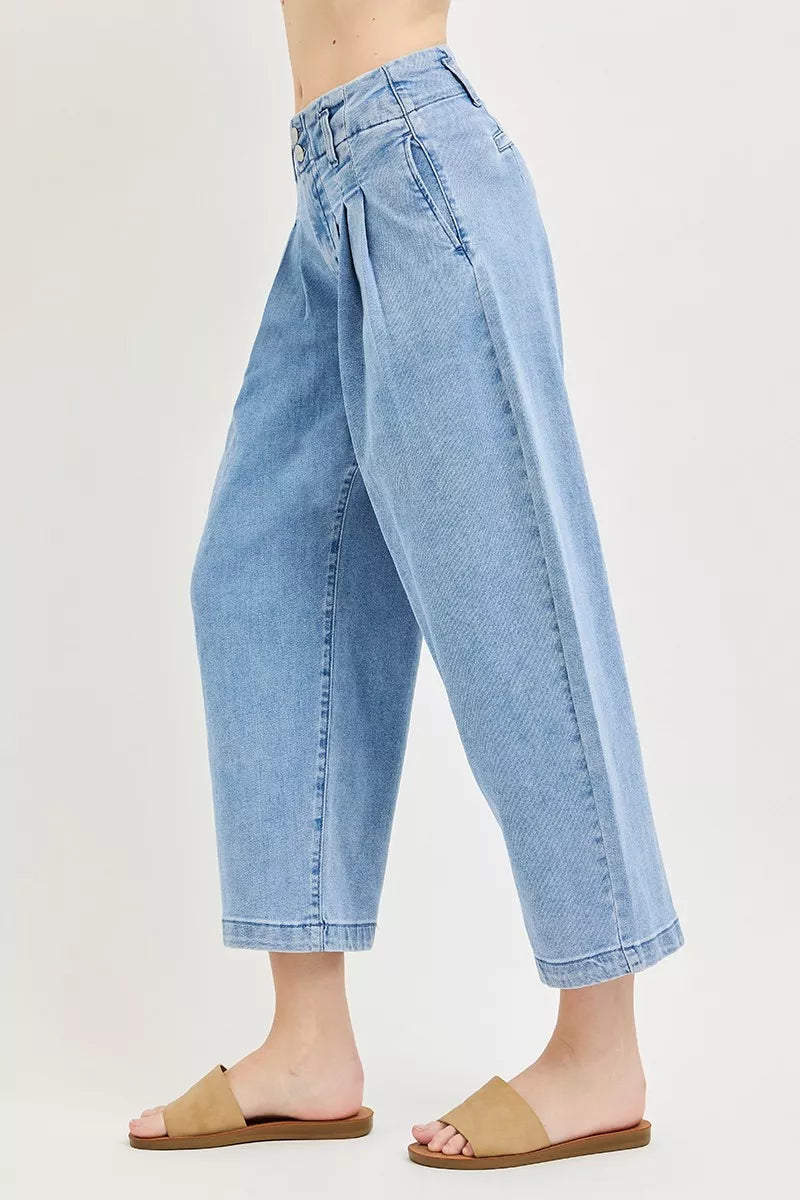 Side view of slouchy crop barrel pleated jeans in medium wash with cuffed hem