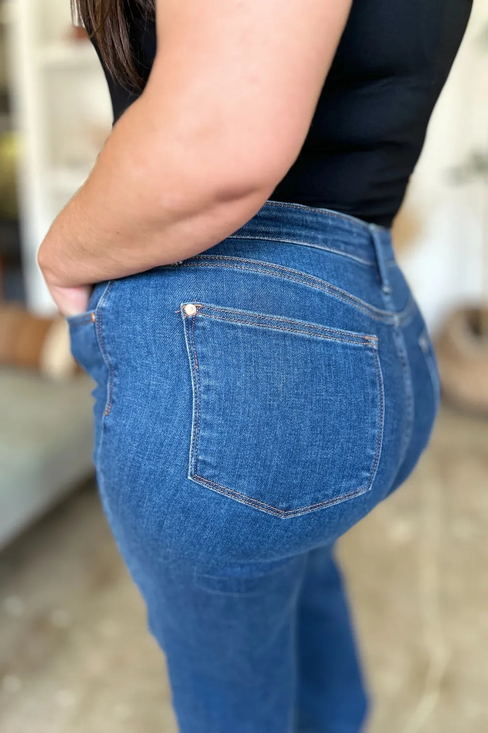 Close-up of medium blue jeans: front pocket and belt loops on high rise