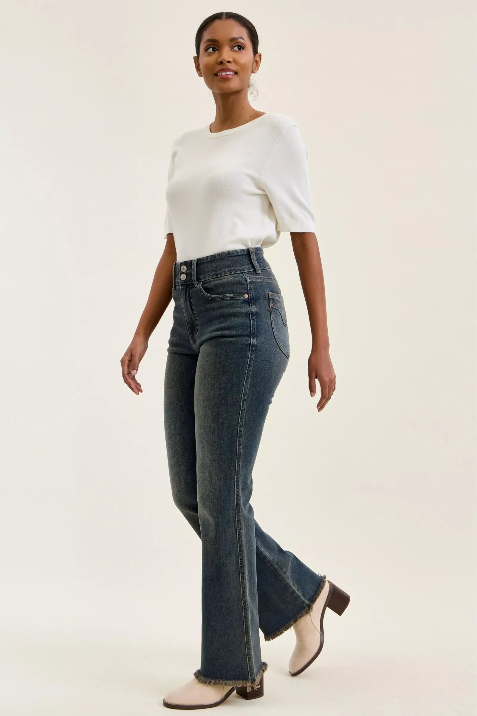 High-waist dark denim jeans with wide leg fit and frayed ankle hem, double-button front.