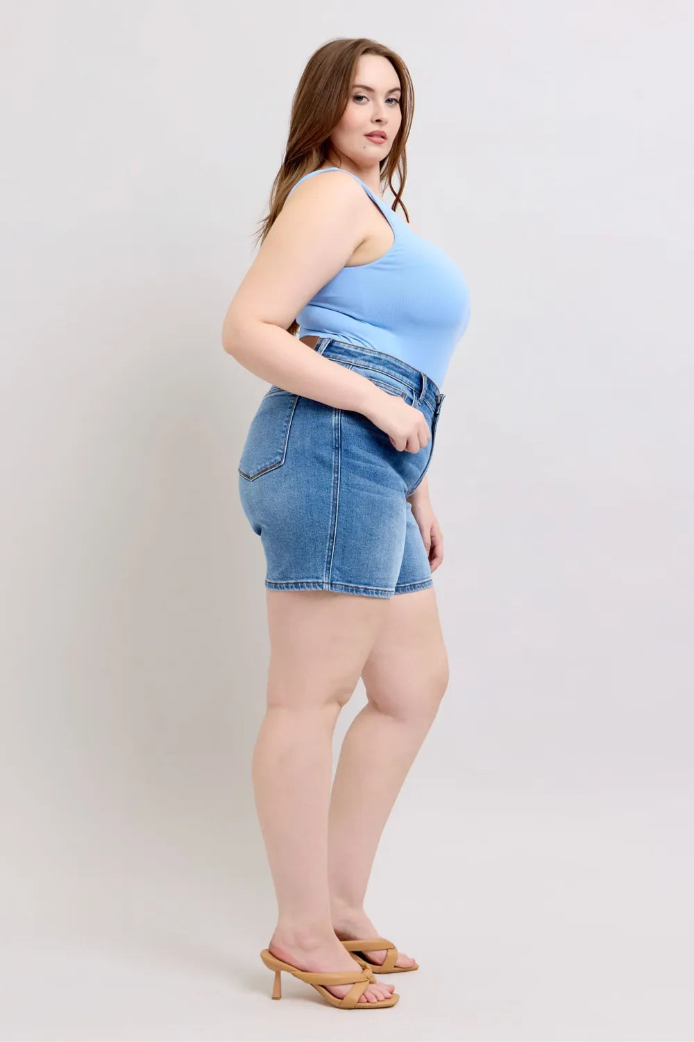 3/4 view: plus size medium-wash denim shorts with front pockets