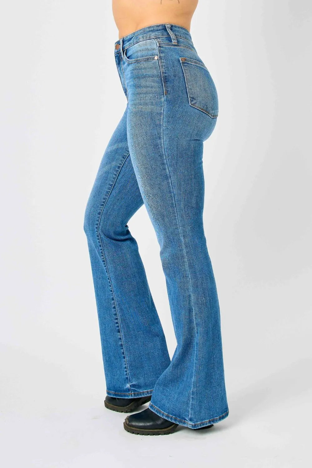 Side profile of medium-blue high-waisted flare jeans with stitched front seams