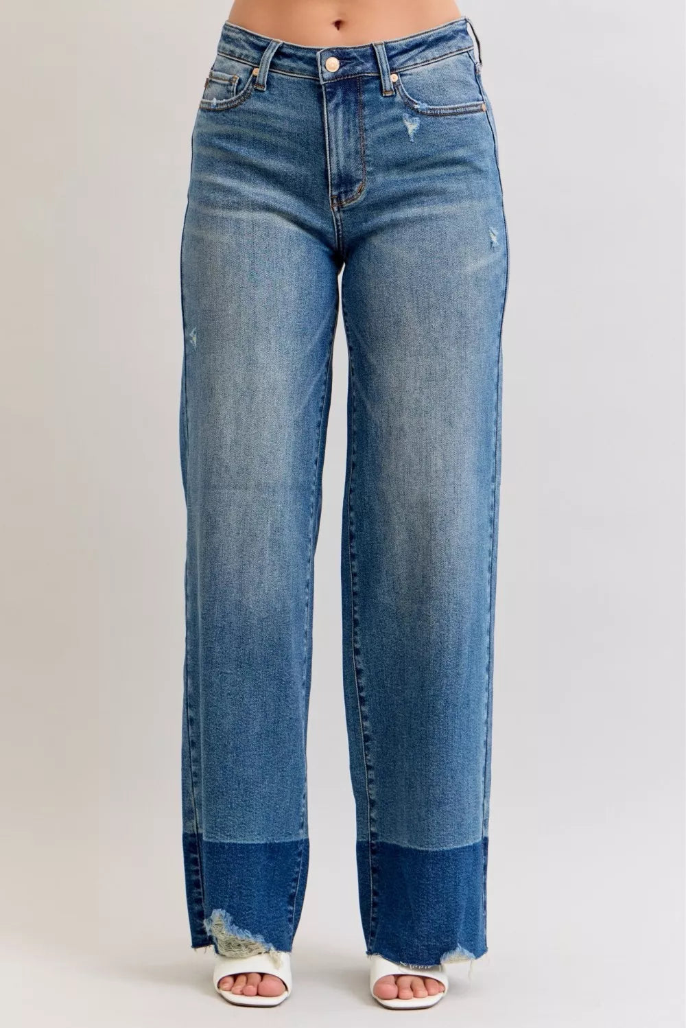Front view of high-waist straight jeans in dark denim with raw hem and button closure