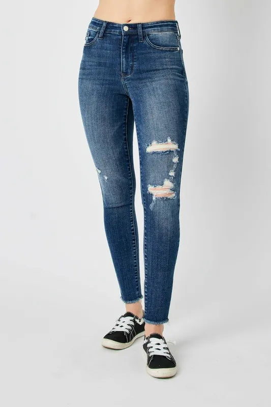 High-waist skinny jeans, dark denim wash, front distressing at mid-thigh and knees