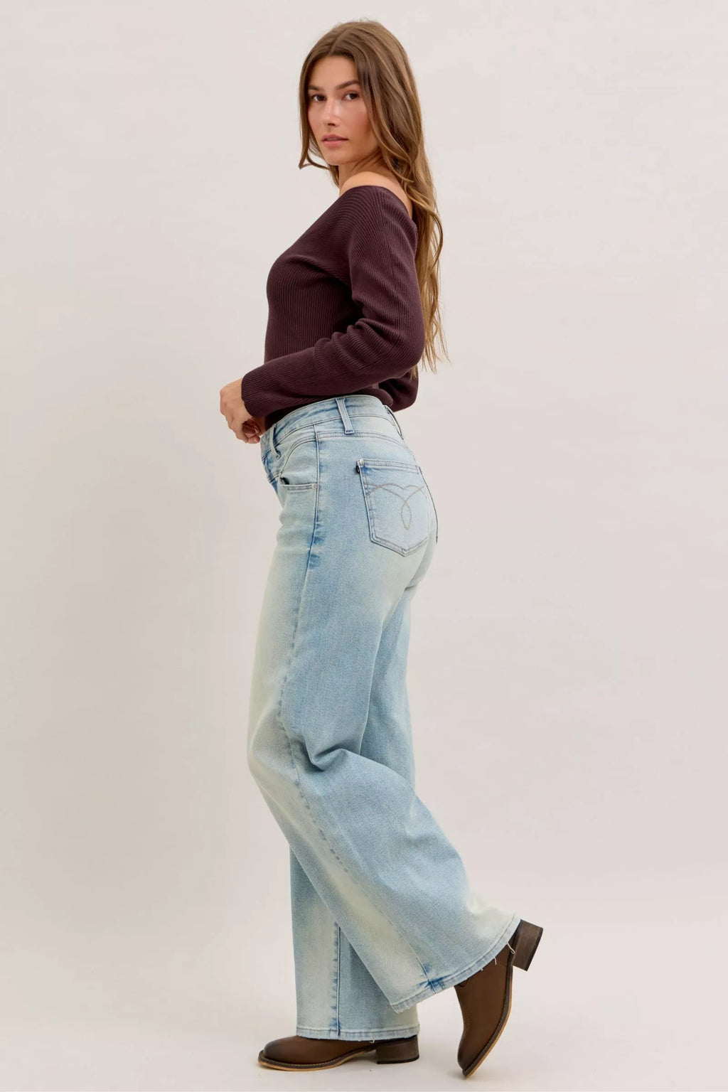 Light blue high-waist straight jeans, front 3/4 view with button fly and front pocket stitching
