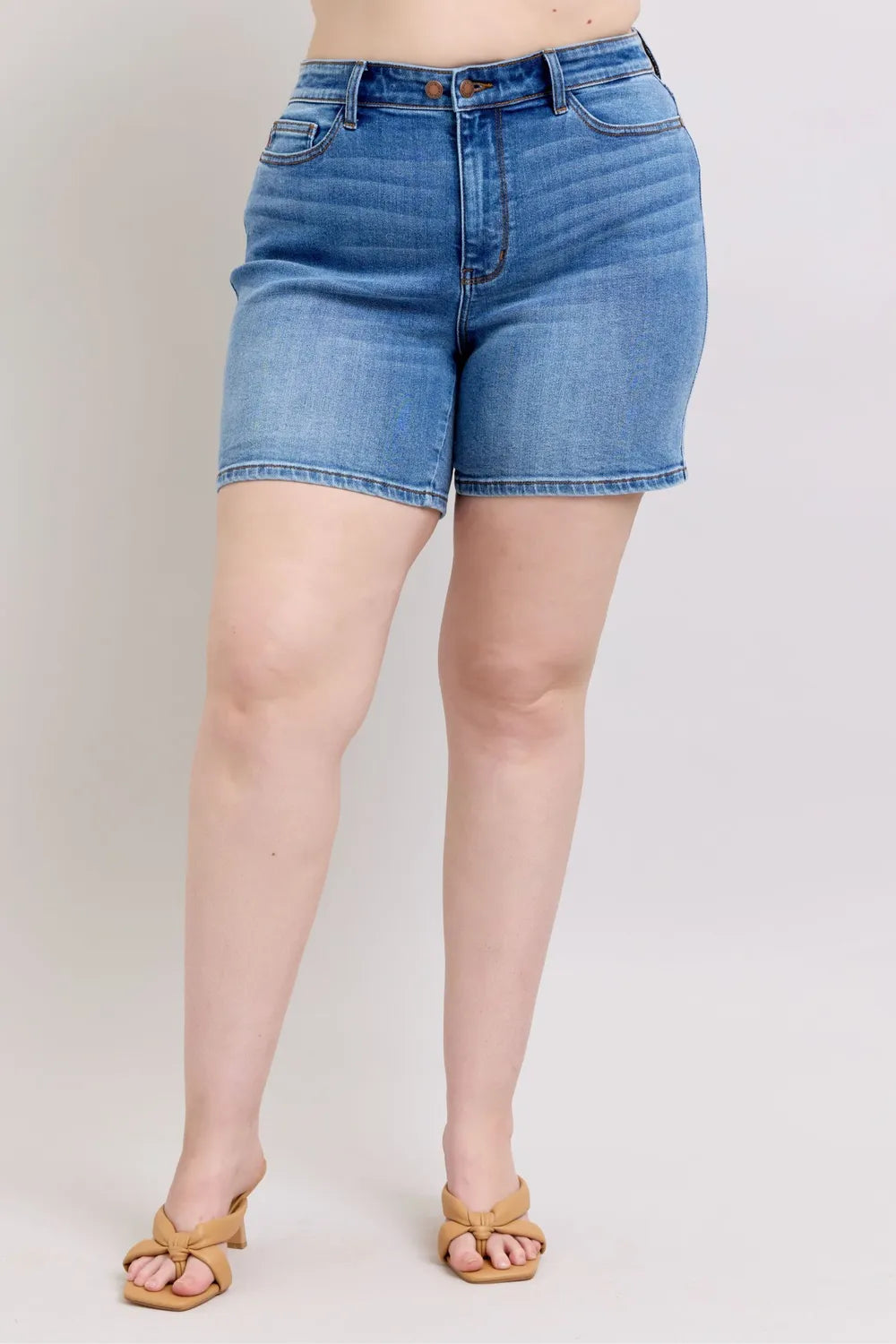 Medium wash denim shorts with two-button front and pockets, plus size