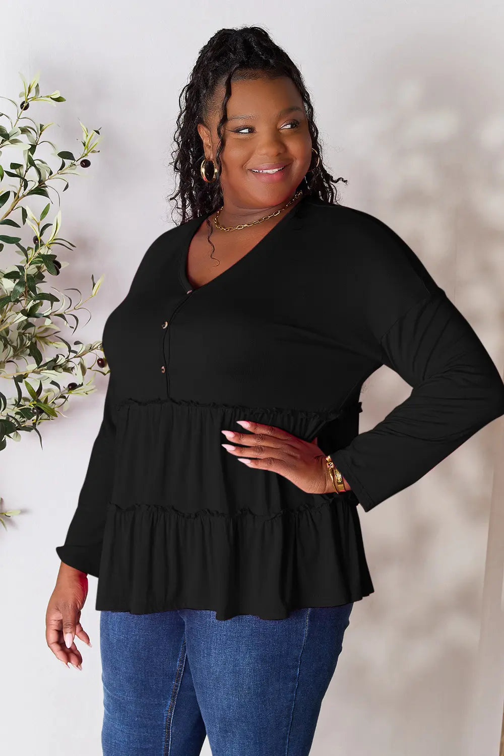 Black long sleeve blouse with V-neck half-button front and tiered ruffle hem