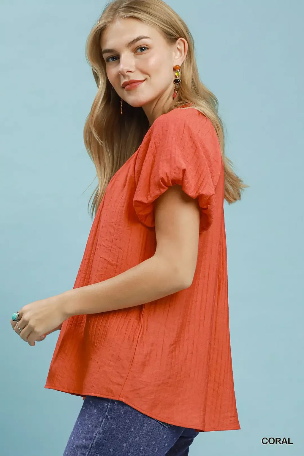 Coral gathered V-neck blouse in side view with fluttery short sleeves