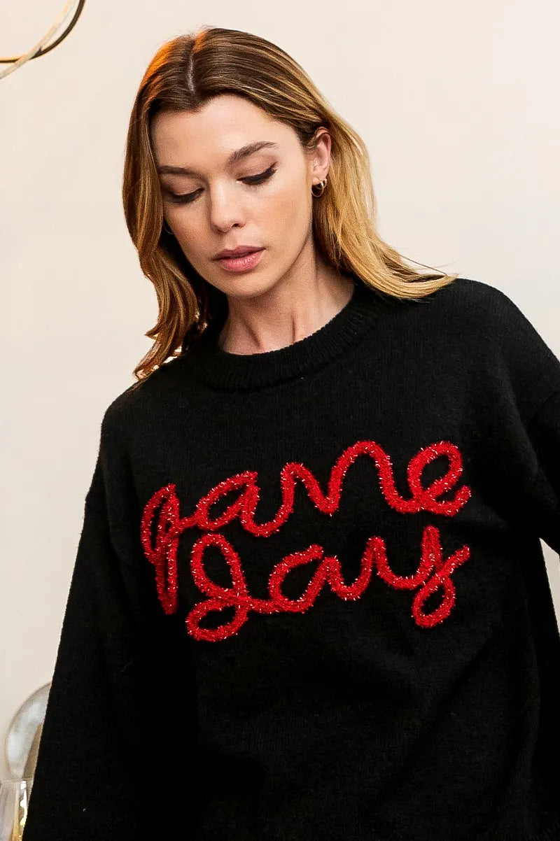Black sweater close-up: red “Game Day” lettering on the front