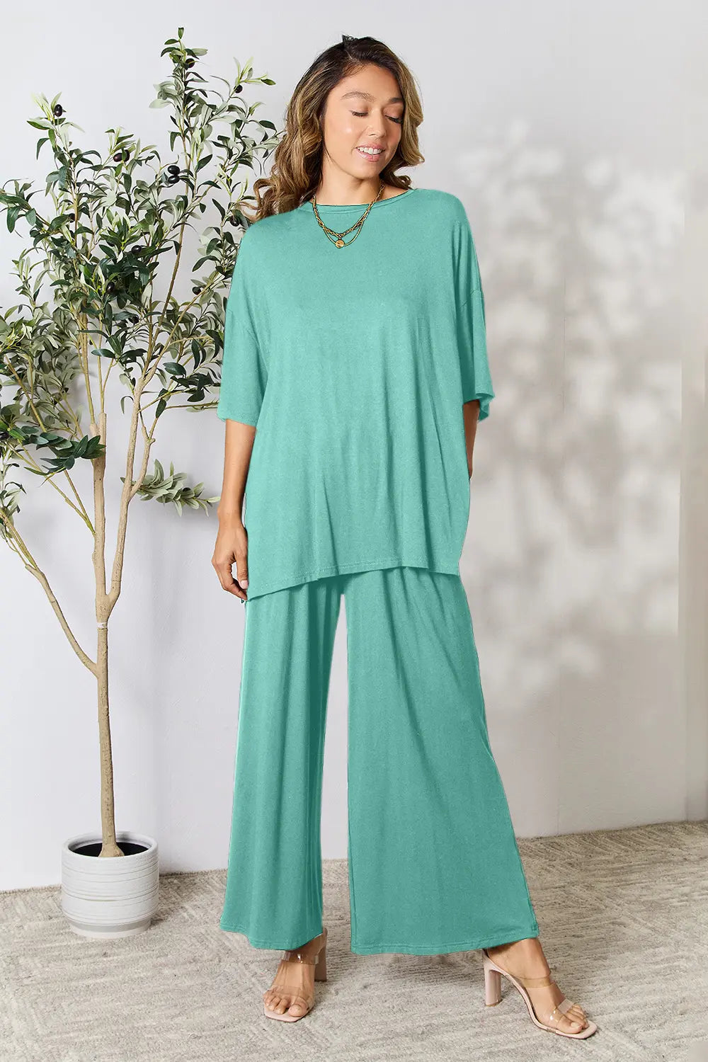 Set in teal: loose round-neck slit top with wide-leg pants, 3/4-length sleeves
