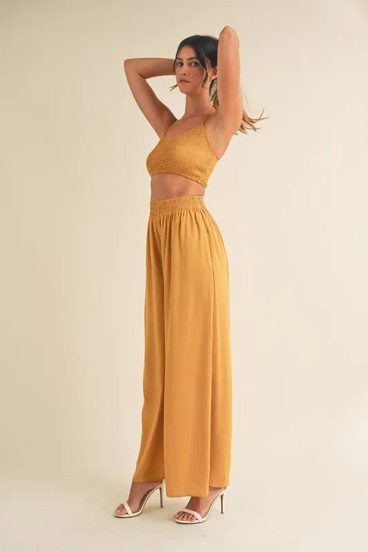 Gold mustard smocked bralette crop top with high-waist wide-leg pants, back view