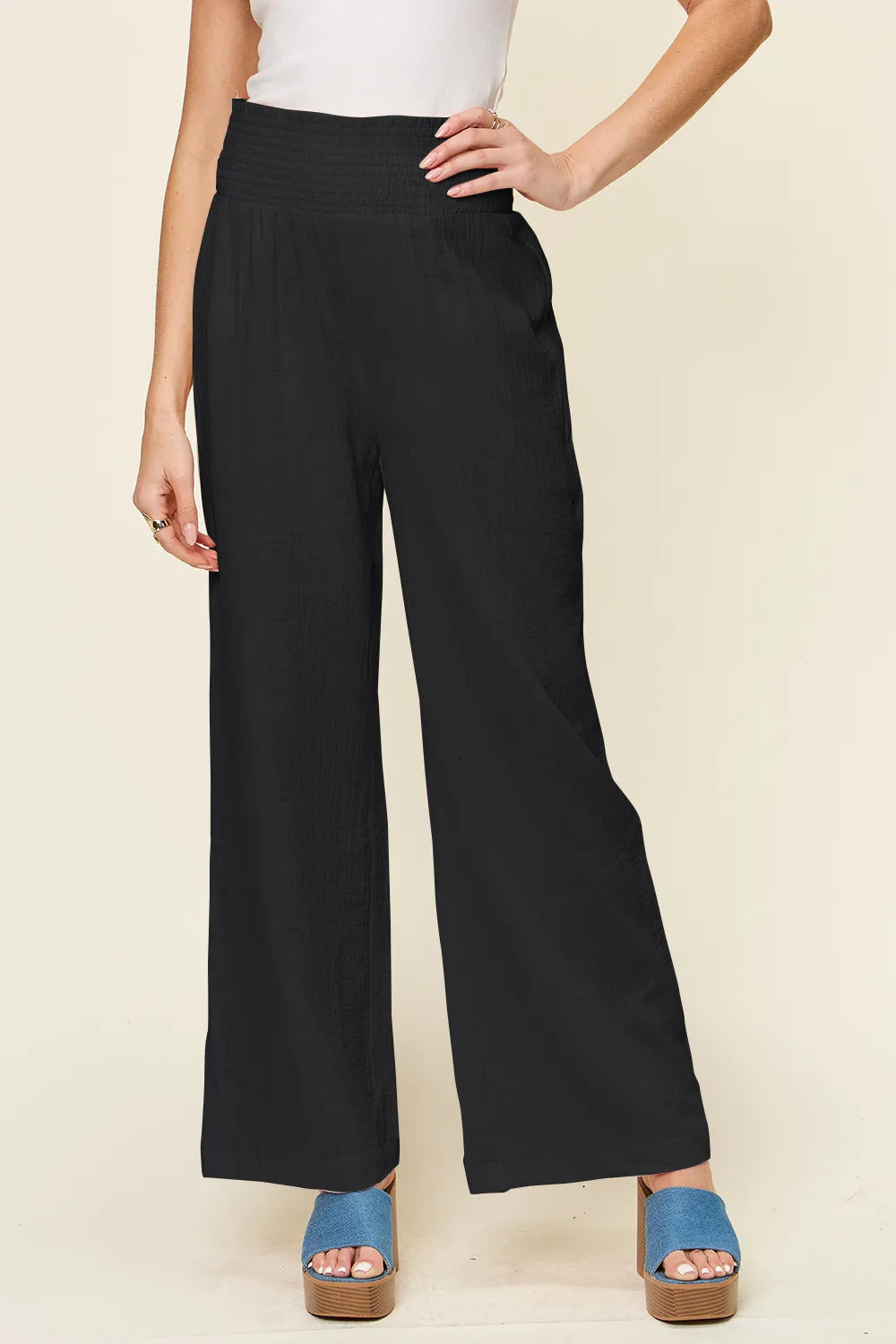 Black wide-leg pants with smocked waist and textured finish