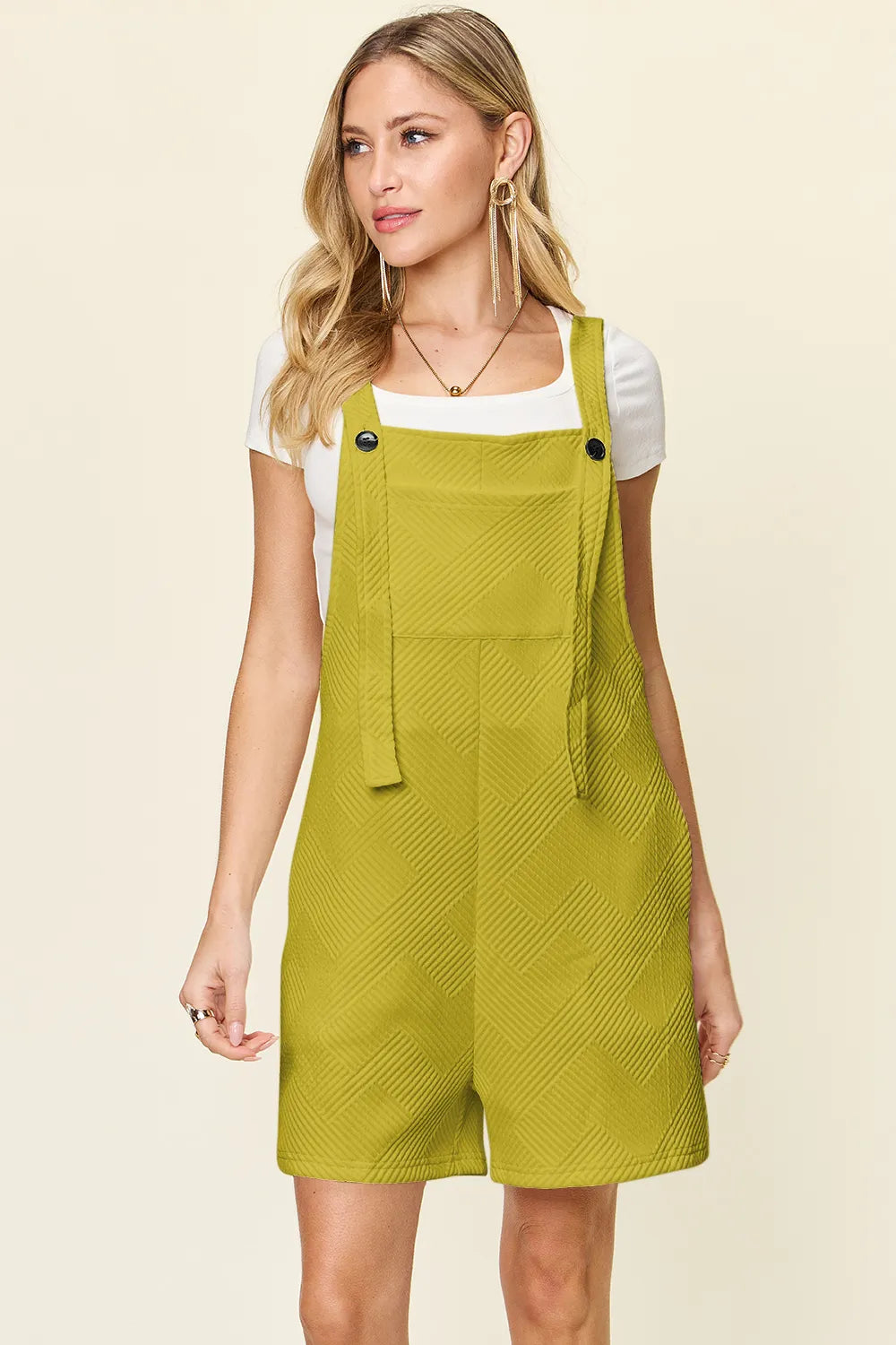 Chartreuse textured sleeveless romper with bib front, button details, short legs