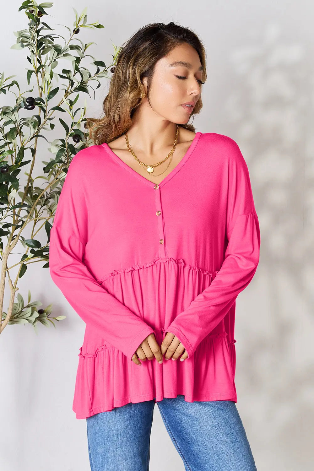 Hot pink tiered ruffle blouse with V-neck half-button front, long sleeves, side view