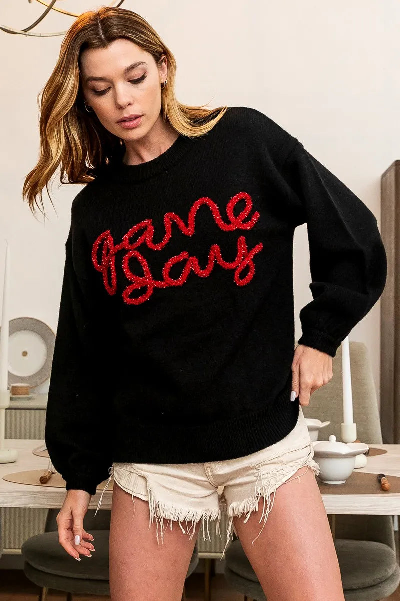 Black knit sweater with red “Game Day” front text and ribbed cuffs