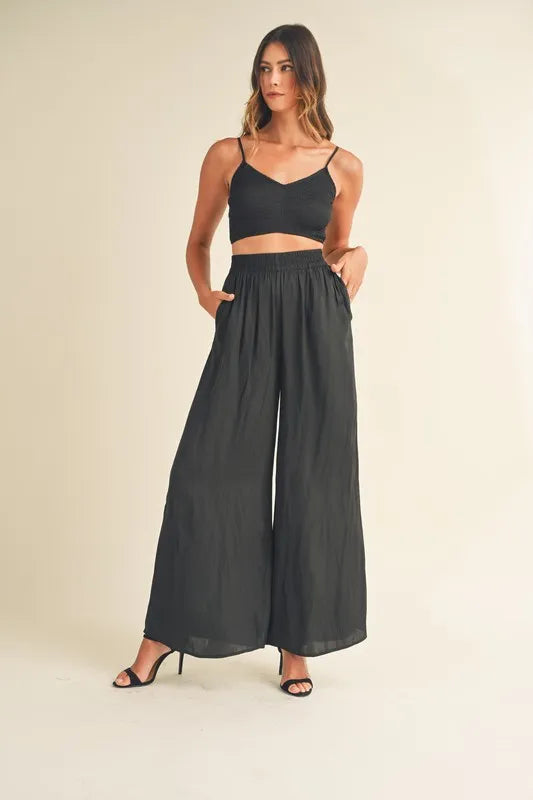 Conjunto negro: bralette corto con tirantes finos y pantalón ancho con cintura fruncida