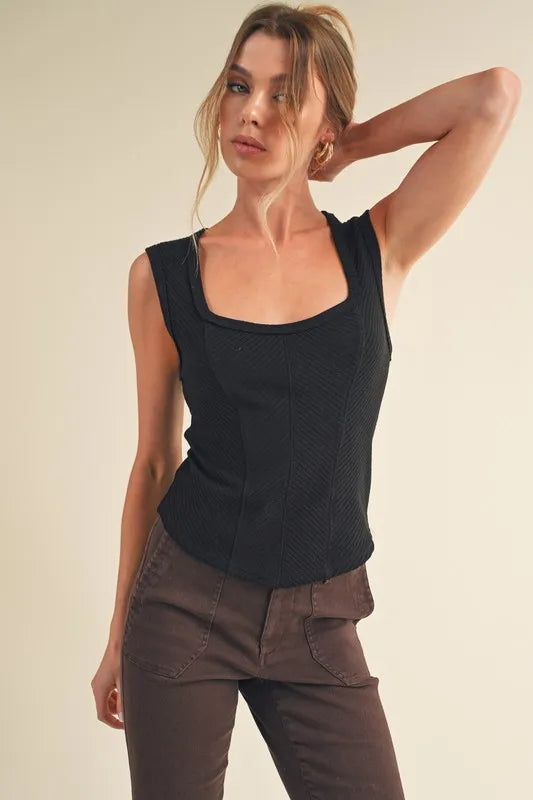 Black ribbed tank top with wide straps and exposed seams